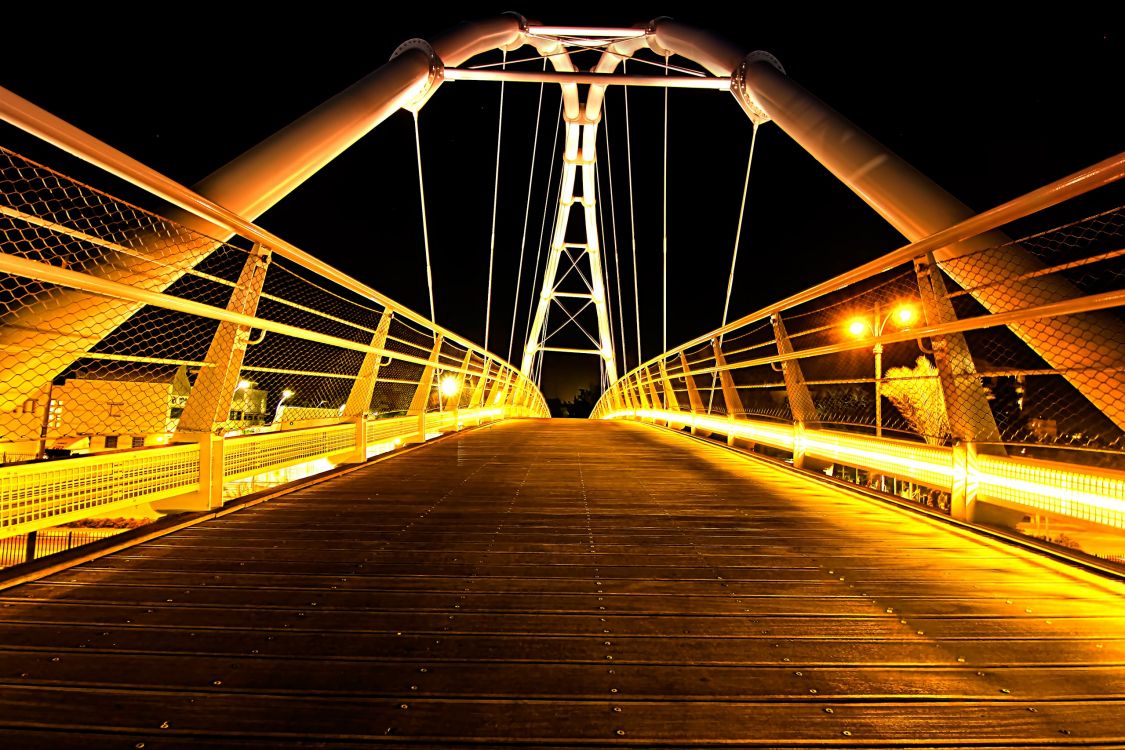 brown wooden bridge with light post during night time