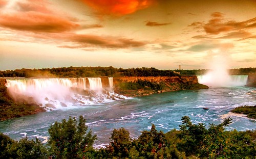 Image waterfalls near green trees under cloudy sky during daytime