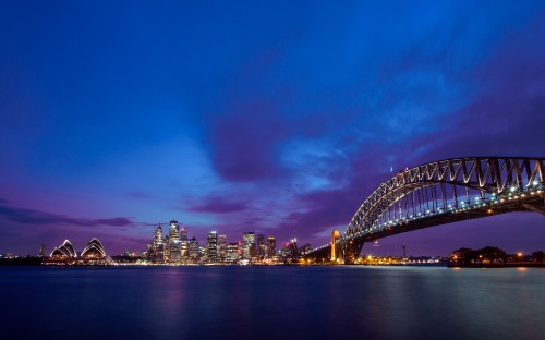 Image city skyline under blue sky during night time