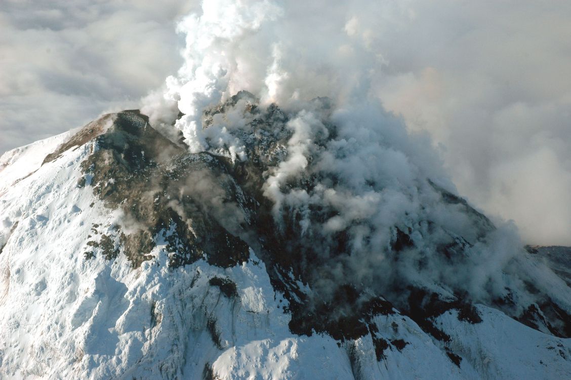 snow covered mountain under white clouds during daytime