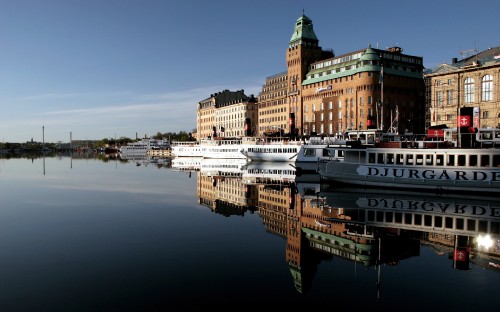 Image white and black boat on water near city buildings during daytime