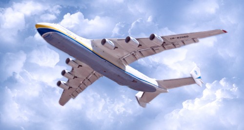 Image white and blue airplane under white clouds and blue sky during daytime