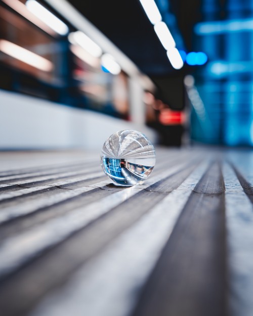 Image clear glass ball on gray wooden plank