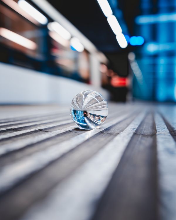 clear glass ball on gray wooden plank