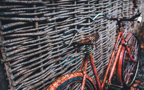 Image orange bicycle on black metal fence