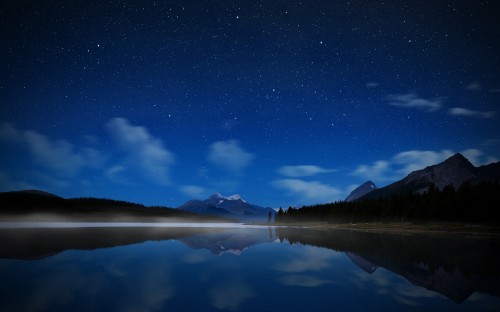 Image body of water near mountain under blue sky during night time