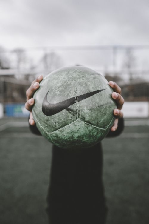 person holding green and black ball