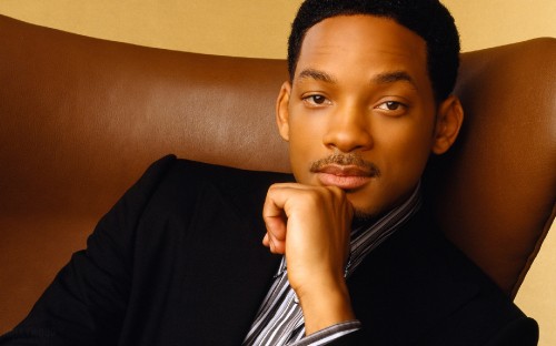 Image man in black blazer sitting on brown sofa