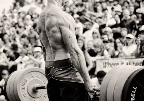 Image topless man in black shorts carrying barbell