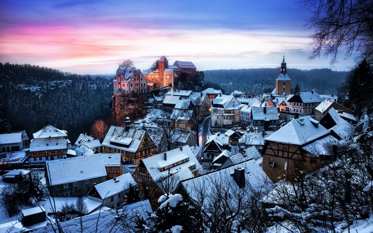 white and brown houses near mountain under cloudy sky during daytime