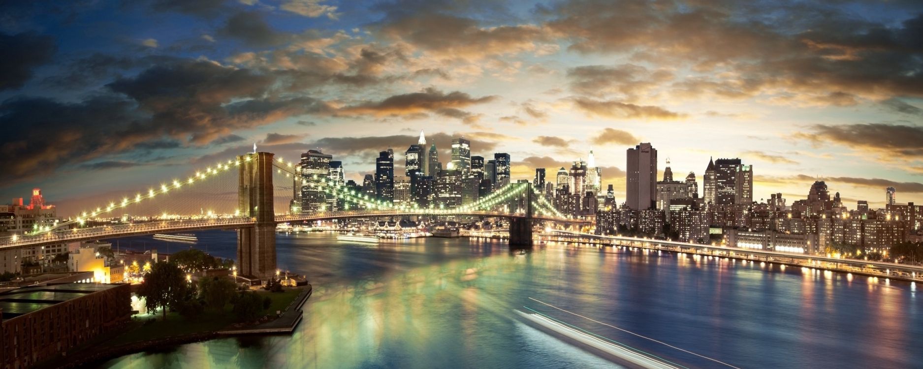 city skyline across body of water during night time