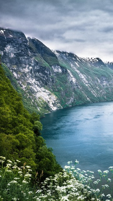 Image green lake between green mountains under white clouds during daytime