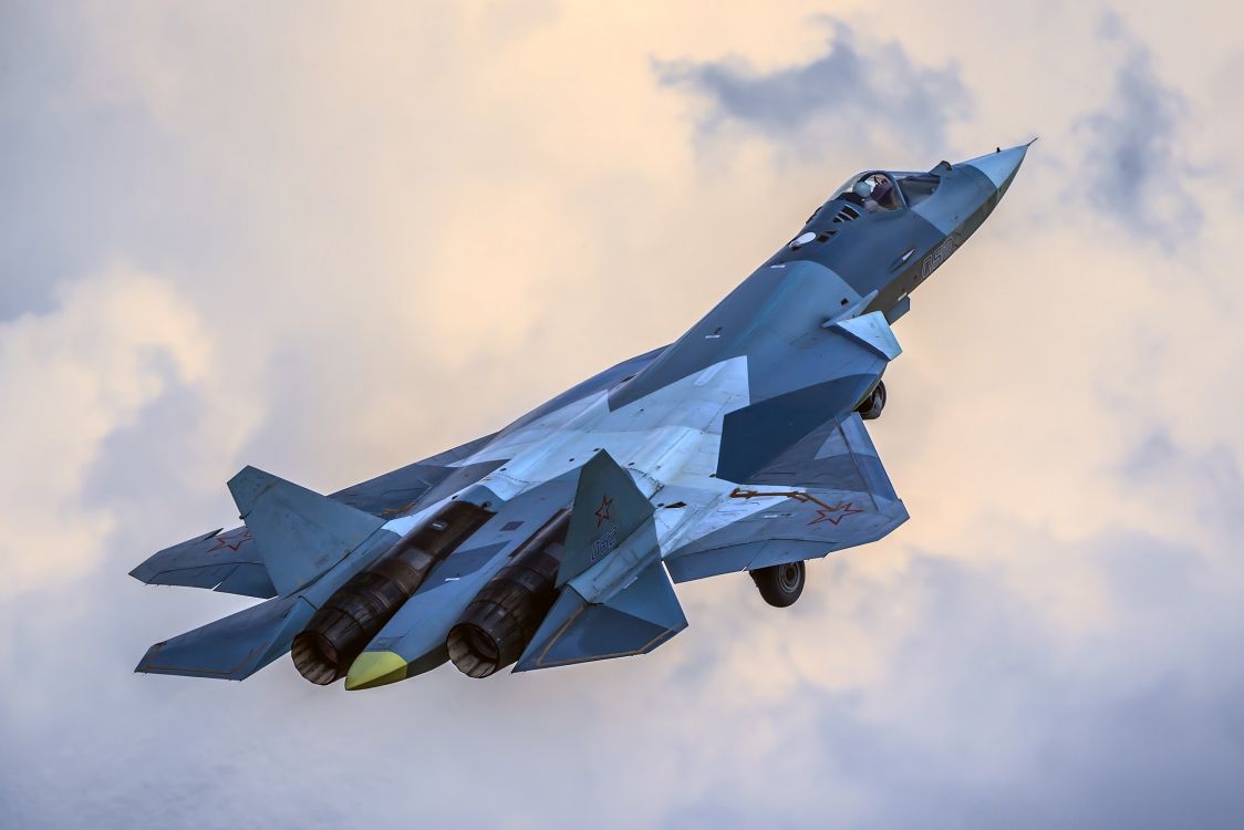 blue jet plane in mid air during daytime