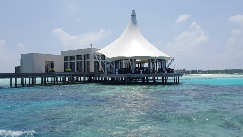 Image brown wooden gazebo on body of water during daytime