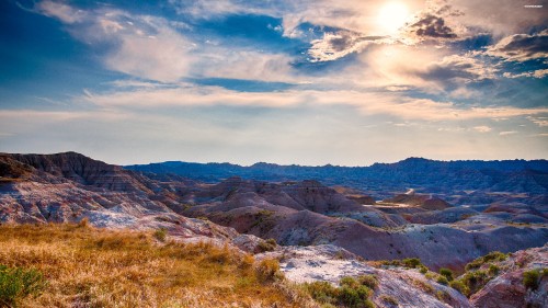 Image brown and green mountains under white clouds and blue sky during daytime