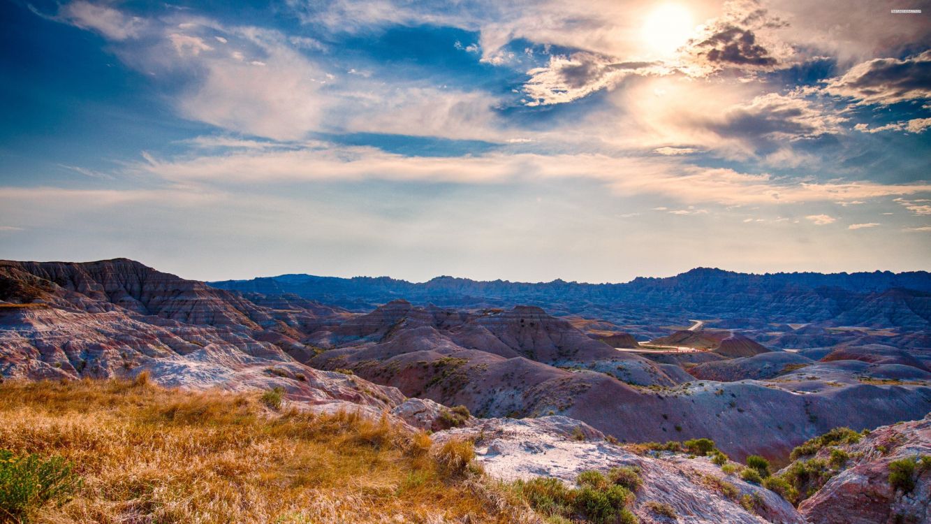 brown and green mountains under white clouds and blue sky during daytime