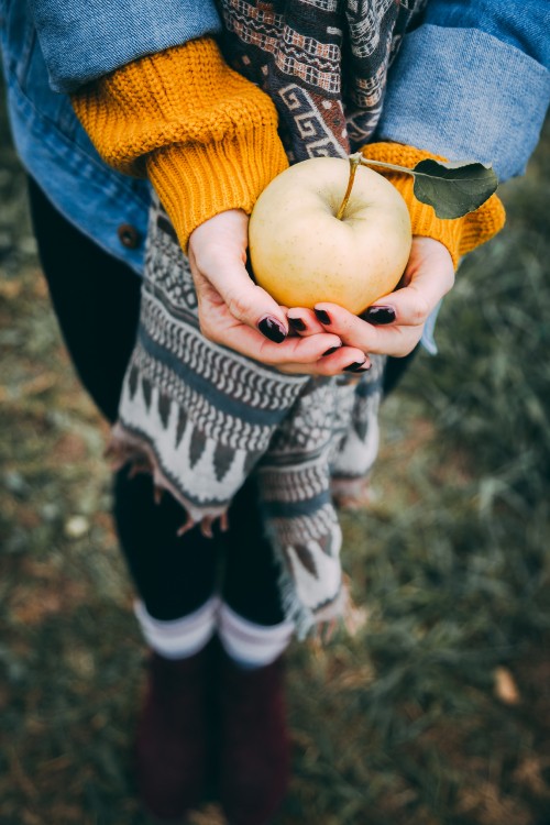 Image person holding yellow round fruit