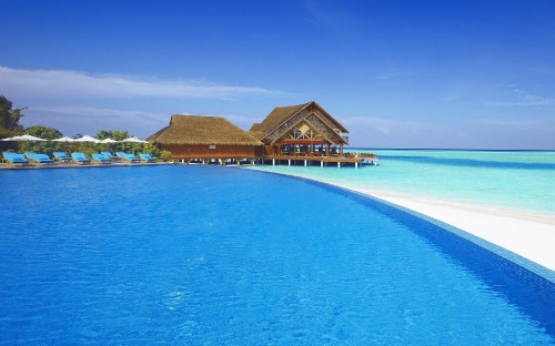 Image brown wooden house on blue sea under blue sky during daytime