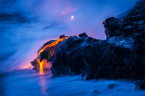 Image brown rock formation on body of water during night time