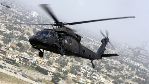 Image black and gray helicopter flying over the city during daytime