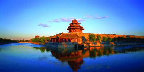 Image brown and black temple near lake under blue sky during daytime