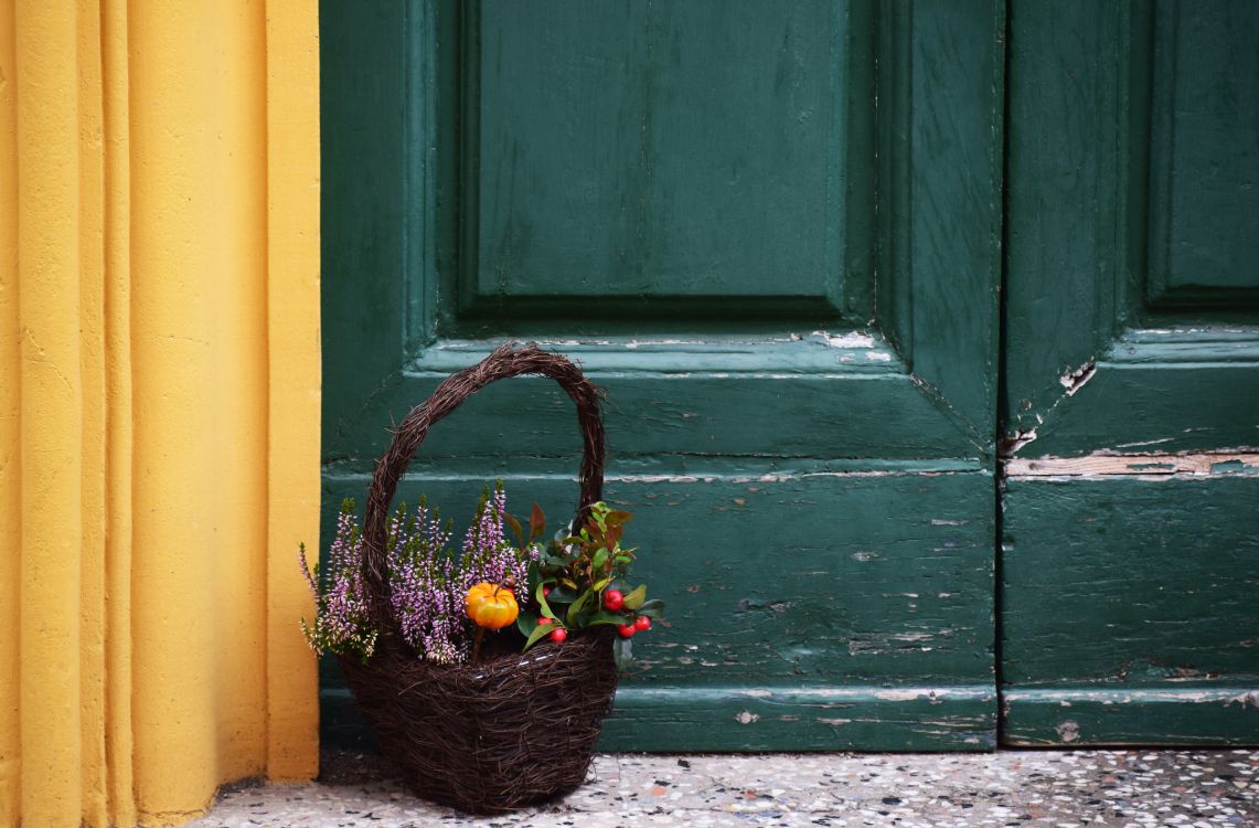 brown wicker basket with green leaves on gray concrete floor