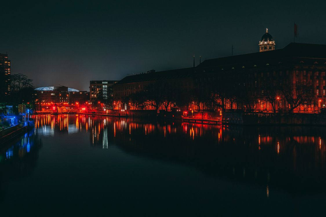 body of water near city buildings during night time