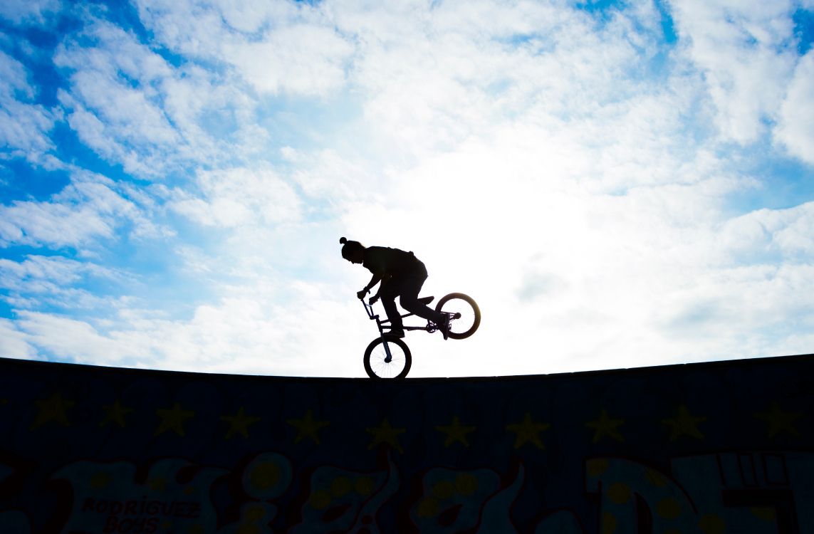 Man Riding Bicycle on Mid Air Sous Ciel Bleu Pendant la Journée. Wallpaper in 5769x3785 Resolution