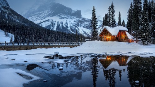 Image brown wooden house on snow covered ground near snow covered mountain during daytime