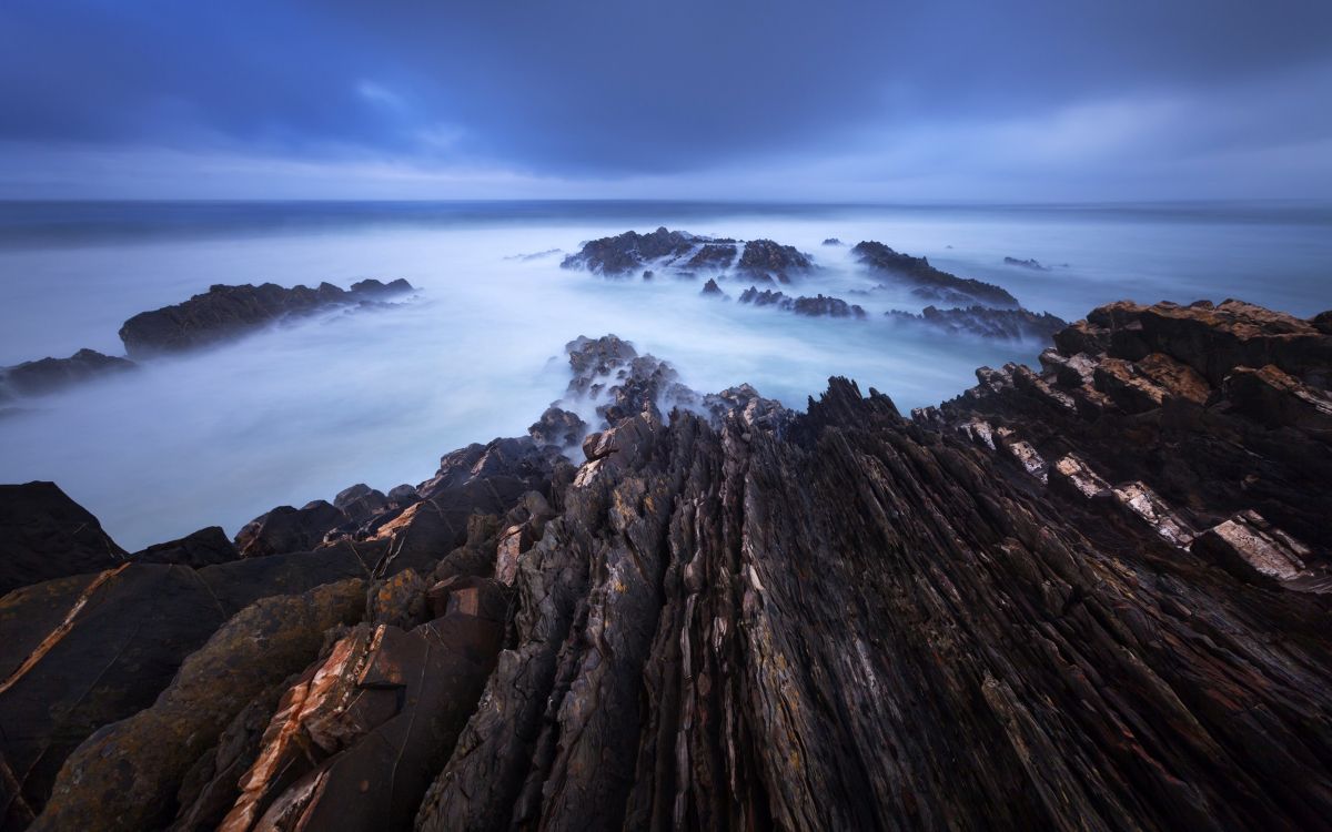 brown rock formation under white clouds during daytime