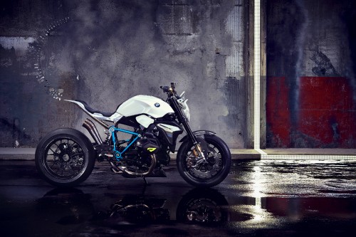 Image white and black naked motorcycle parked beside gray wall