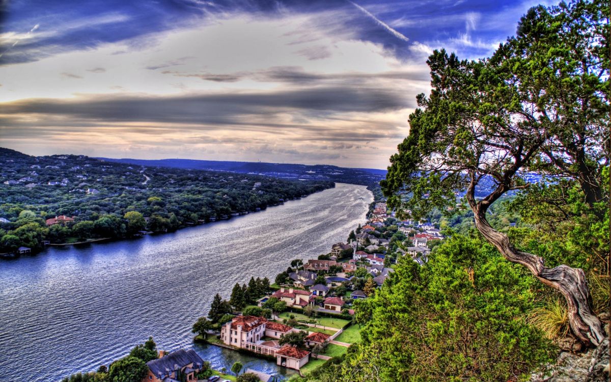 Maisons Sur Terrain D'herbe Verte Près D'un Plan D'eau Sous un Ciel Nuageux Pendant la Journée. Wallpaper in 1920x1200 Resolution