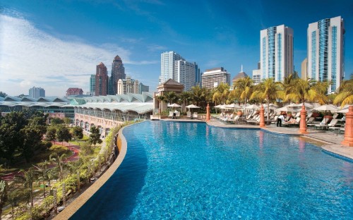 Image white and brown concrete buildings near swimming pool during daytime