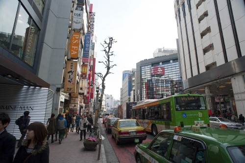 Image people walking on sidewalk near cars on road during daytime