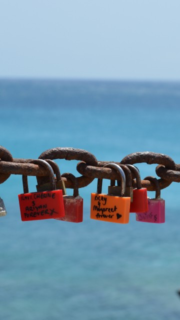 Image padlocks on gray metal fence during daytime