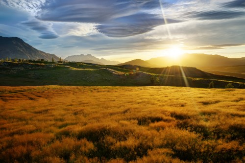 Image green grass field near mountain under blue sky during daytime