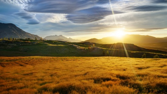 Image green grass field near mountain under blue sky during daytime