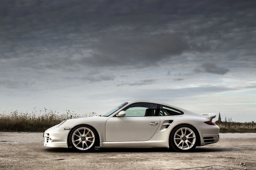 Image white porsche 911 on gray asphalt road under gray cloudy sky