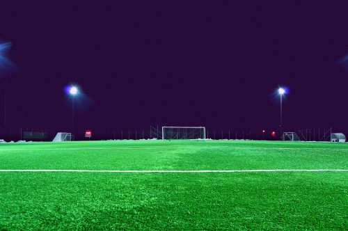 Image soccer goal net on green field during night time