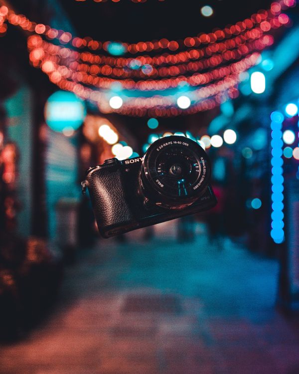 Black Dslr Camera on Blue and White String Lights. Wallpaper in 3456x4320 Resolution