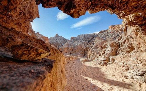 Image brown rocky mountain under blue sky and white clouds during daytime