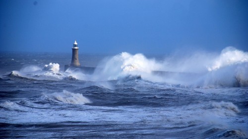 Image white and black lighthouse on sea waves during daytime