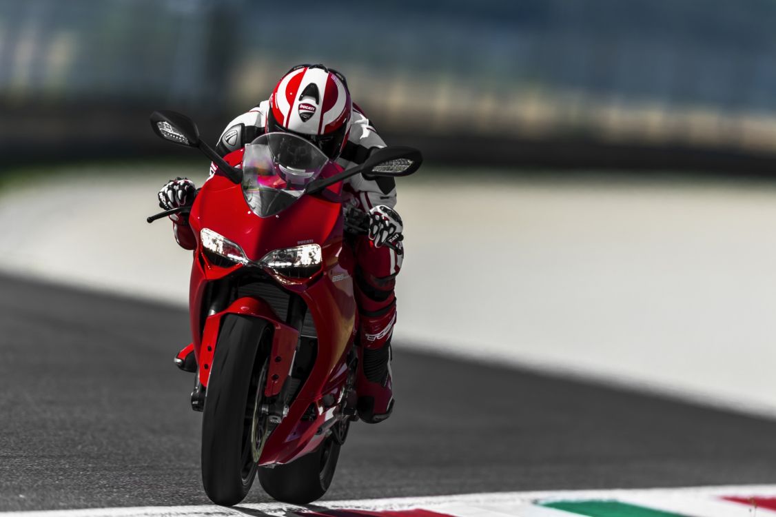 man in red and black motorcycle helmet riding on red sports bike