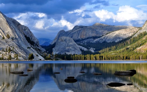 Image lake near green and brown mountains under white clouds and blue sky during daytime