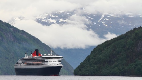 Image white and blue ship on water near mountain during daytime