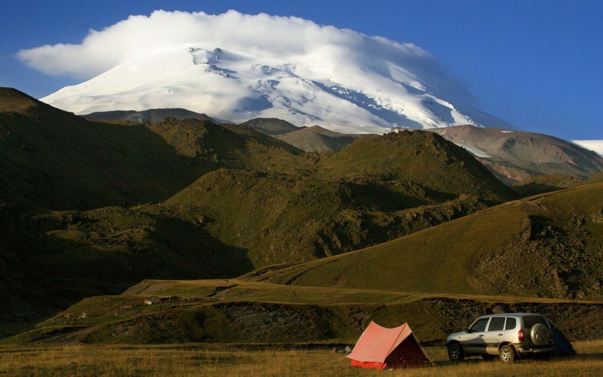 Rotes Zelt Auf Grüner Wiese in Der Nähe Des Berges Unter Weißen Wolken Und Blauem Himmel Tagsüber. Wallpaper in 1920x1200 Resolution
