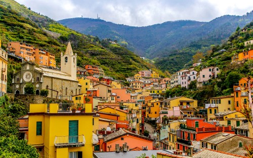 Image yellow and brown concrete houses near green mountains during daytime