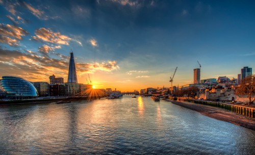 Image body of water near city buildings during sunset