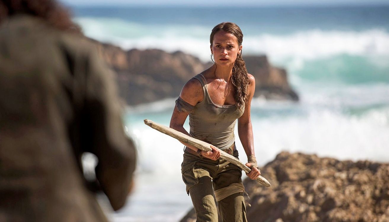 woman in brown tank top and brown pants holding brown wooden stick