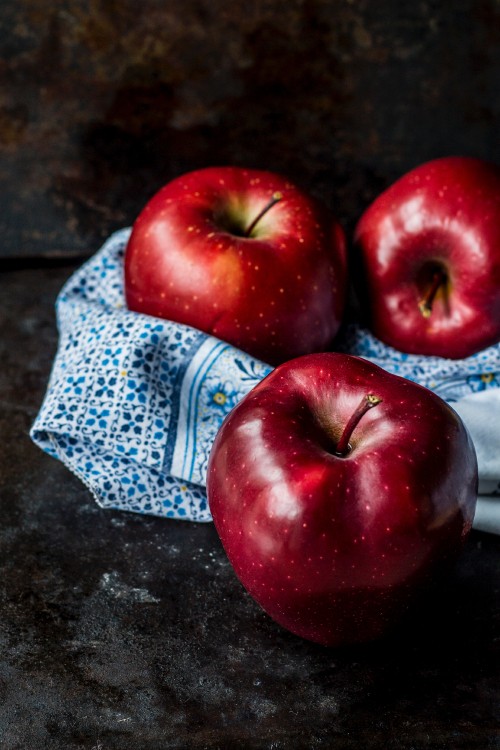 Image red apple on blue and white textile